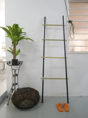 a black shelf with a plant next to a table at little heritage home in George Town