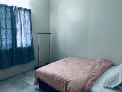 a bedroom with a bed and a shower curtain at CoZy and comfortable Homestay in sungai siput in Sungai Siput