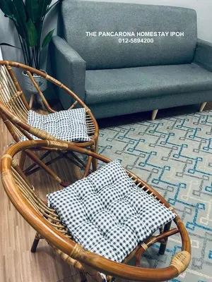 a wicker rocking chair and a couch in a living room at The Pancarona Homestay forMuslims, Ipoh, Perak in Ipoh