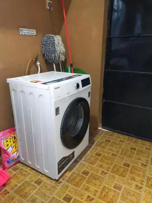 a washing machine sitting on the floor next to a door at RIZQI HOMESTAY Sungai Siput with Wifi! Islamic Guest Only! in Kampong Rimba Panjang