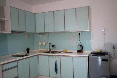 a kitchen with white cabinets and a sink and a refrigerator at Seaview Mansion One Georgetown in George Town