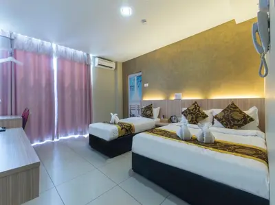 a hotel room with two beds and a large window at Top Garden Hotel in Hutan Melintang