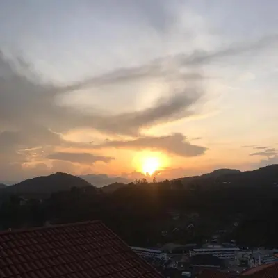 a sunset over a city with the sun in the sky at Merlin Home@Crown Imperial Court in Tanah Rata