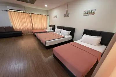 a room with three beds and a couch at Inapan Taman Herba in Kepala Batas