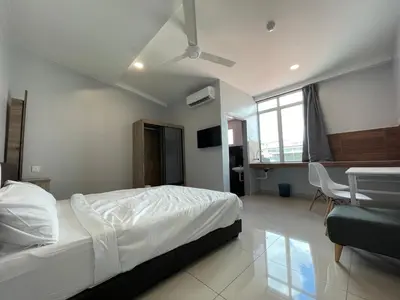 a bedroom with a bed and a desk and a table at Reno Hotel Ipoh in Ipoh