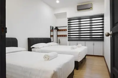 a room with three beds with white sheets and a window at Ipoh Garden Comfort Homestay in Ipoh