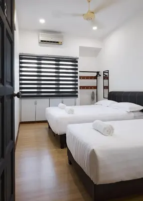 a room with three beds and a window at Ipoh Garden Comfort Homestay in Ipoh