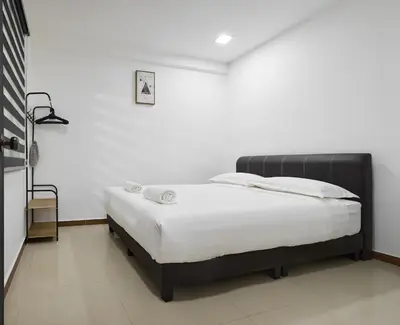 a bedroom with a bed in a white room at Ipoh Garden Comfort Homestay in Ipoh