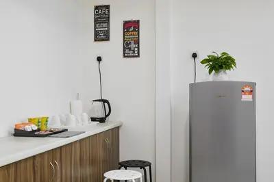 a kitchen with a refrigerator and a counter with stools at Ipoh Garden Comfort Homestay in Ipoh