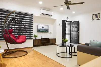 a living room with a red chair in a swing at Ipoh Garden Comfort Homestay in Ipoh
