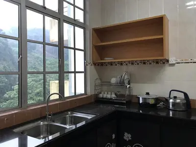 a kitchen with a sink and a counter top with windows at 3 Rooms Apt @ Crown Imperial Court in Cameron Highlands