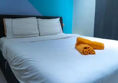 a white bed with two towels on top of it at Kavy Boutique Hotel @ KBH in Brinchang