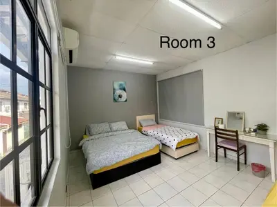 a room with two beds and a desk and a window at 4B12B 20 pax Corner House in Ipoh