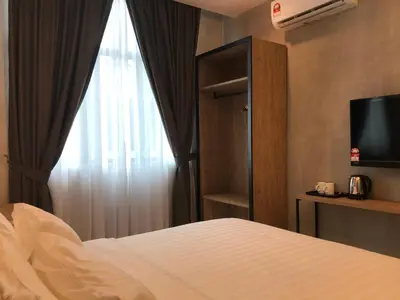 a hotel room with a bed and a window at Dandelion Inn in Simpang Pulai