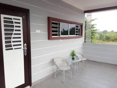 a porch with chairs and a table and a window at Serantau Mayang by the Bliss in Bagan Serai