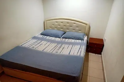 a small bedroom with a bed with blue pillows at Hotel O Prai Jaya in Perai