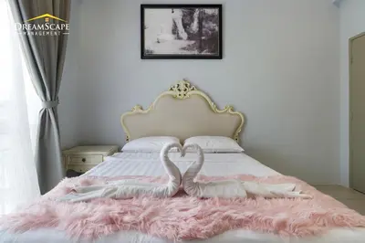 two white swans are sitting on a bed at Zetter Suites by Dreamscape in Cameron Highlands