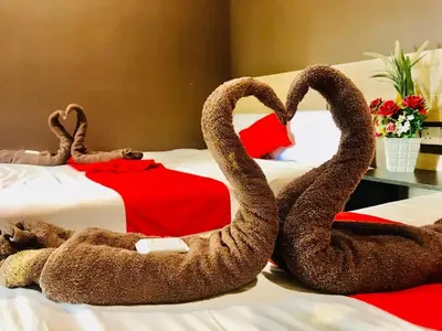 two stuffed swans sitting on top of a bed at Highway Times Inn Hotel in Ipoh