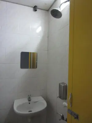 a white bathroom with a sink and a mirror at Happy Owl in Ipoh
