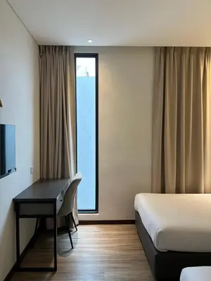 a hotel room with a desk and a bed and a window at The Gallivant Hotel in George Town