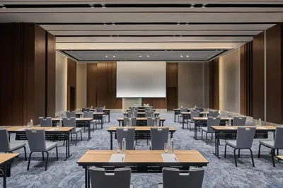 a conference room with tables and chairs and a projection screen at Courtyard by Marriott Penang in George Town