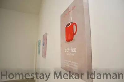a sign on a wall with an apple sign on it at homestay mekar idaman in Kepala Batas