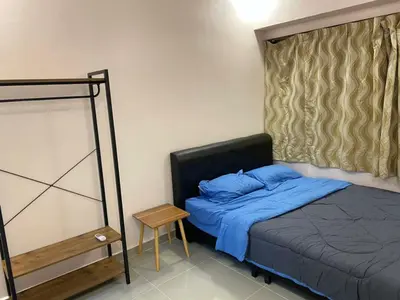 a bedroom with a bed with blue pillows and a table at My Suites Sri Sayang Resort in Batu Ferringhi