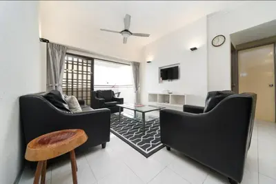 a living room with two black chairs and a table at VIP Seaview Resort Batu Ferringhi 2104 - 2 Rooms in Batu Ferringhi