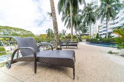 a patio with two chairs and a swimming pool at VIP Seaview Resort Batu Ferringhi 2104 - 2 Rooms in Batu Ferringhi