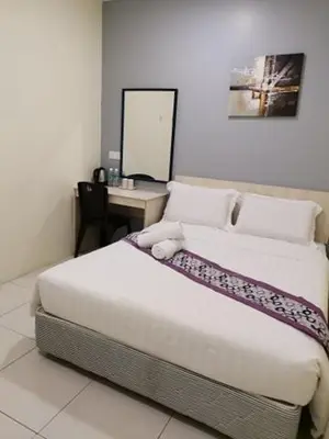 a bedroom with a bed and a table with a mirror at LH Hotel Langkap Perak in Kampung Degong