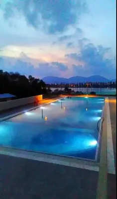 a large swimming pool with blue water at night at Marina Height Seaview Resort, Teluk Batik, Lumut in Kampong Tebing Rabak