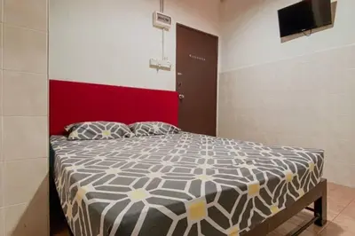 a bedroom with a bed with a black and white comforter at SK Budget Hotel in Jelutong