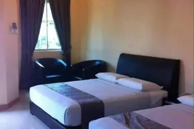 a hotel room with two beds and a window at SK Budget Hotel in Jelutong