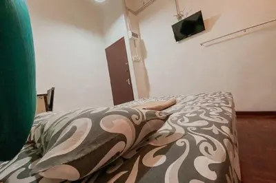 a bedroom with a bed with a comforter and pillow at SK Budget Hotel in Jelutong
