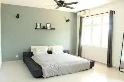 a bedroom with a bed with a ceiling fan at NEW SEAVIEW Cozy Modern Beach House in Tanjung Bungah