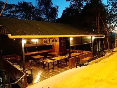 a restaurant with tables and chairs on a wooden deck at Utan Teluk Nipah in Pangkor