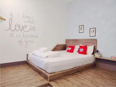 a bedroom with a large bed with red pillows at Winggarden Murals House by JE Boutique Guesthouse in Ipoh