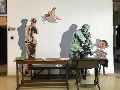 a table with statues on it in front of a wall at Winggarden Murals House by JE Boutique Guesthouse in Ipoh