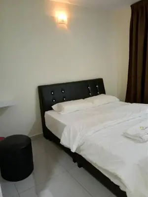 a bed with a black headboard in a room at 28 Gred Hotel in Bukit Mertajam