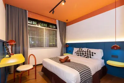 a hotel room with a bed and a desk and a window at Parkland Suites in Brinchang