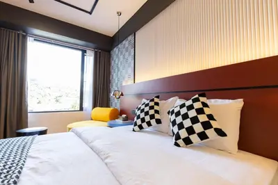 a hotel room with a bed and a window at Parkland Suites in Brinchang