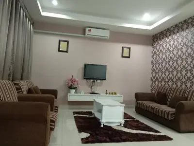 a living room with two couches and a tv at TRIPLE A Homestay in Ipoh