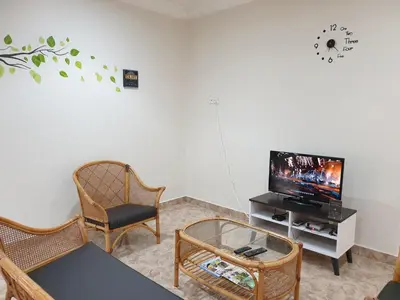 a living room with a tv and a table and chairs at Taiping Cuti Homstay \u592a\u5e73\u7af9\u7b1b\u6c11\u5bbf 5mins to Kuala Sepetang in Taiping
