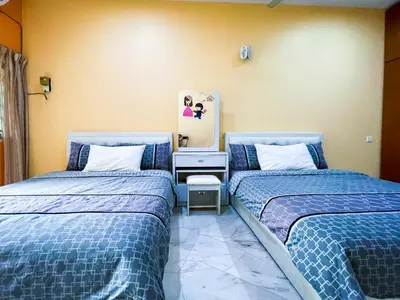 two beds sitting next to each other in a room at Gather Here 62 5BR Town Center 5 Rooms in Taiping