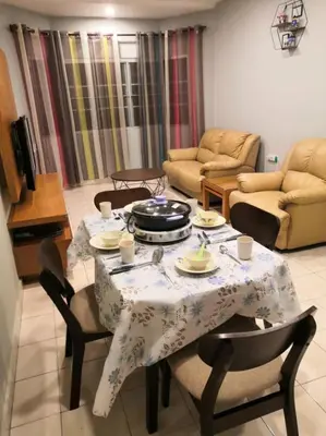a living room with a table and chairs and a table and chairsktop at Green Hill Resort Tanah Rata 3R2B WiFi in Tanah Rata