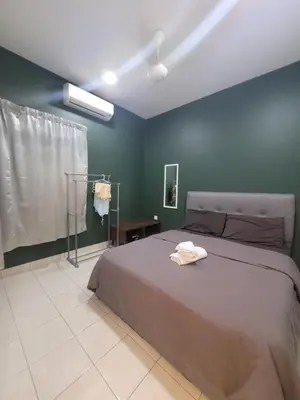 a bedroom with a bed and a green wall at Ipoh Meru Modern Cozy Home NAZ IPOH HOMESTAY in Ipoh