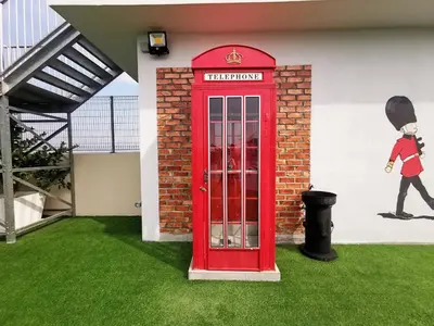 a red phone booth next to a building with a mural at The Venus Sitiawan Breezee Spacious Homestay 6 to 8 Pax in Kampong Lumut Kiri