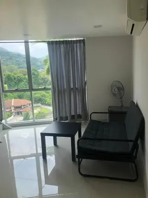 a room with a couch and a table and a window at The Ceo Suites in Bayan Lepas