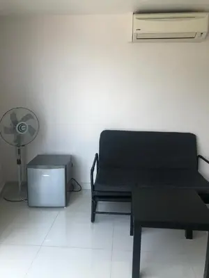 a room with a black couch and a fan at The Ceo Suites in Bayan Lepas