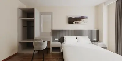 a bedroom with a bed and a desk and a chair at VISTA HOTEL in Kampar